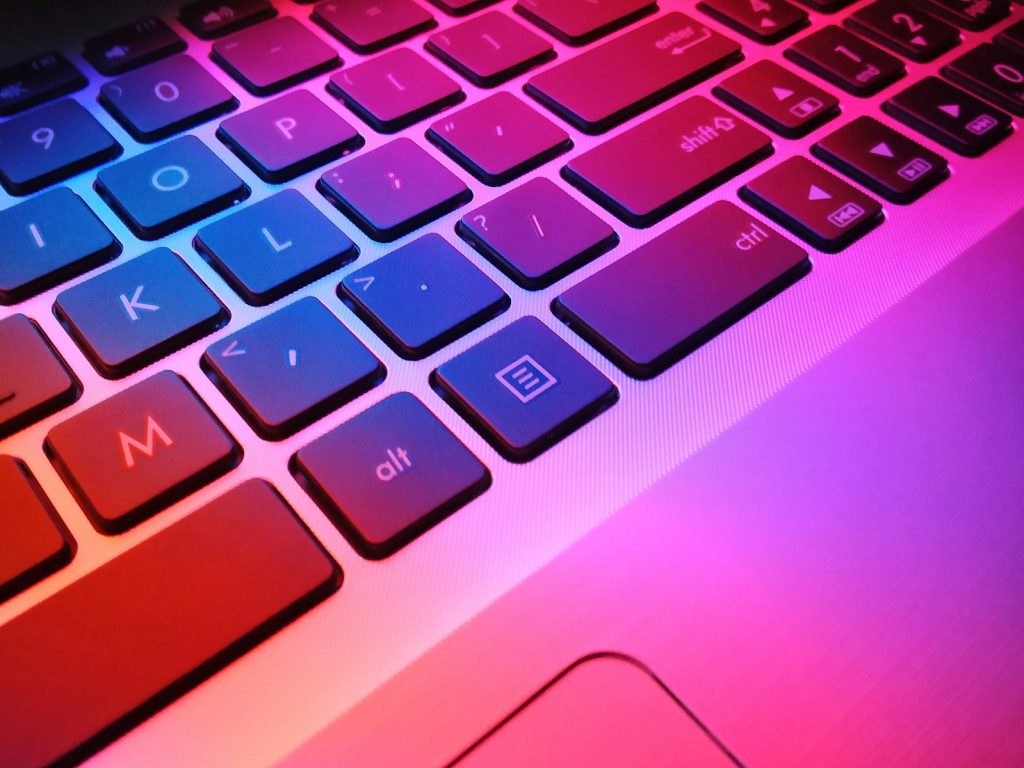 a close up of a laptop keyboard with red and blue keys